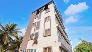 A multi-story hotel building with a sign indicating it offers 24-hour service. - Classic Red Cherry Wagtail (Bengaluru)