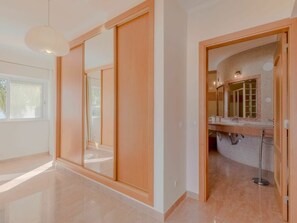 Ein modernes Interieur mit einer Schiebetür, ein Badezimmer mit gefliesten Wänden und einem sichtbaren Duschbereich.