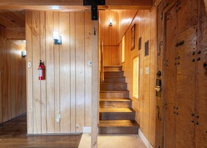 Un interno in legno con una scala, pareti di legno e un estintore.