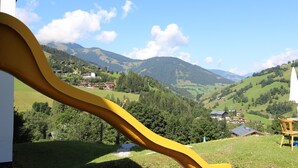 A view of a mountain landscape with houses and a yellow slide in the foreground. - Cozy Holiday Apartment Near the ski Slope (Maria Alm am Steinernen Meer)