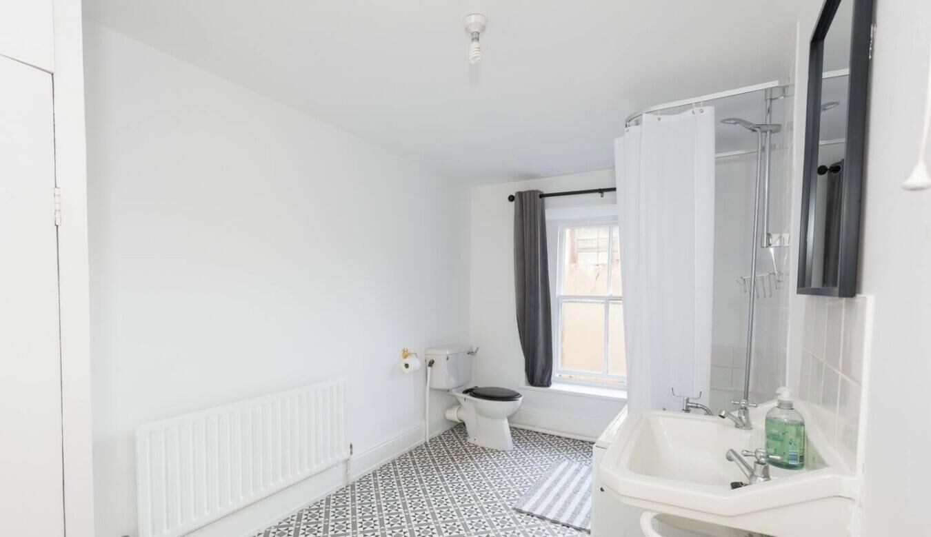 A bathroom with a toilet, sink, and shower.
