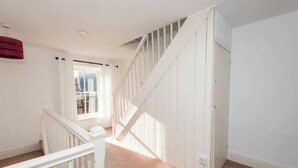 Eine Treppe mit weißen Geländern, die zu einer Zwischenebene führt.