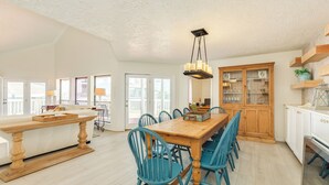 Una cocina amplia con una mesa de comedor de madera, sillas azules y un armario de madera.