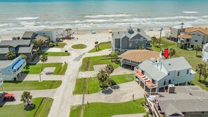 Un área residencial costera con casas, una playa y una vista despejada del océano.