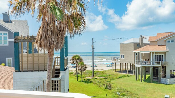Zona residencial costera con casas, una playa y cielo despejado.