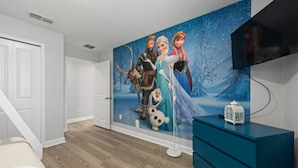 A bedroom with a mural of animated characters, a bed, a dresser, and a television. - Storey Lake Home Pool 15min to Disney (Kissimmee)