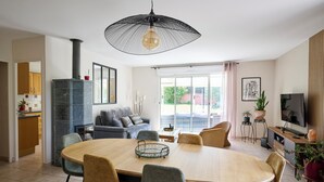 Een moderne woonkamer met een eethoek, een open haard en een televisie.