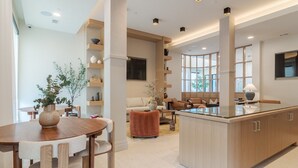 A modern kitchen with a central island, wooden cabinetry, and built-in shelves. - Hyatus Luxury Residences Salem (Salem)