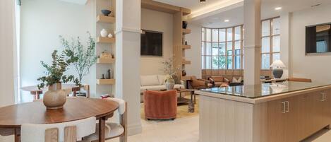 A modern kitchen with a central island, wooden cabinetry, and built-in shelves.