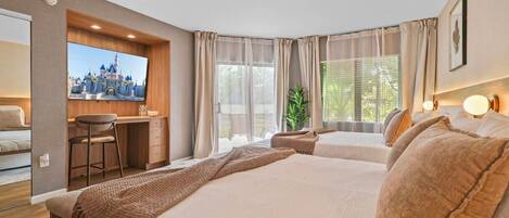 A hotel room with a bed, a desk, a chair, a television, and a window with curtains.