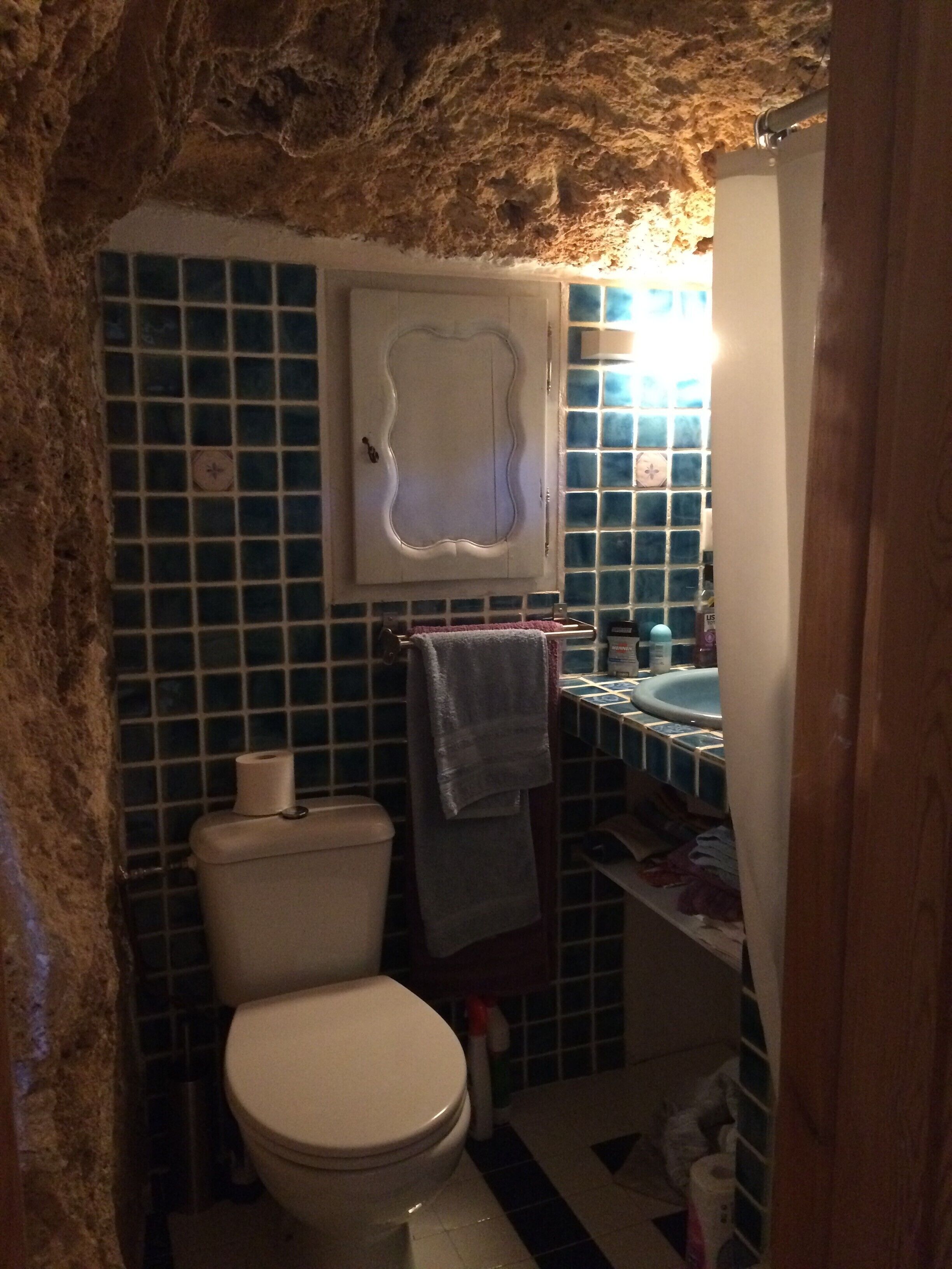 Une salle de bain avec des toilettes, un lavabo et des murs carrelés.