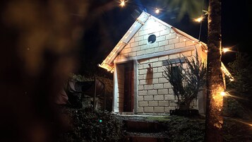 Una pequeña casa de ladrillo con techo inclinado, una puerta visible y una ventana.