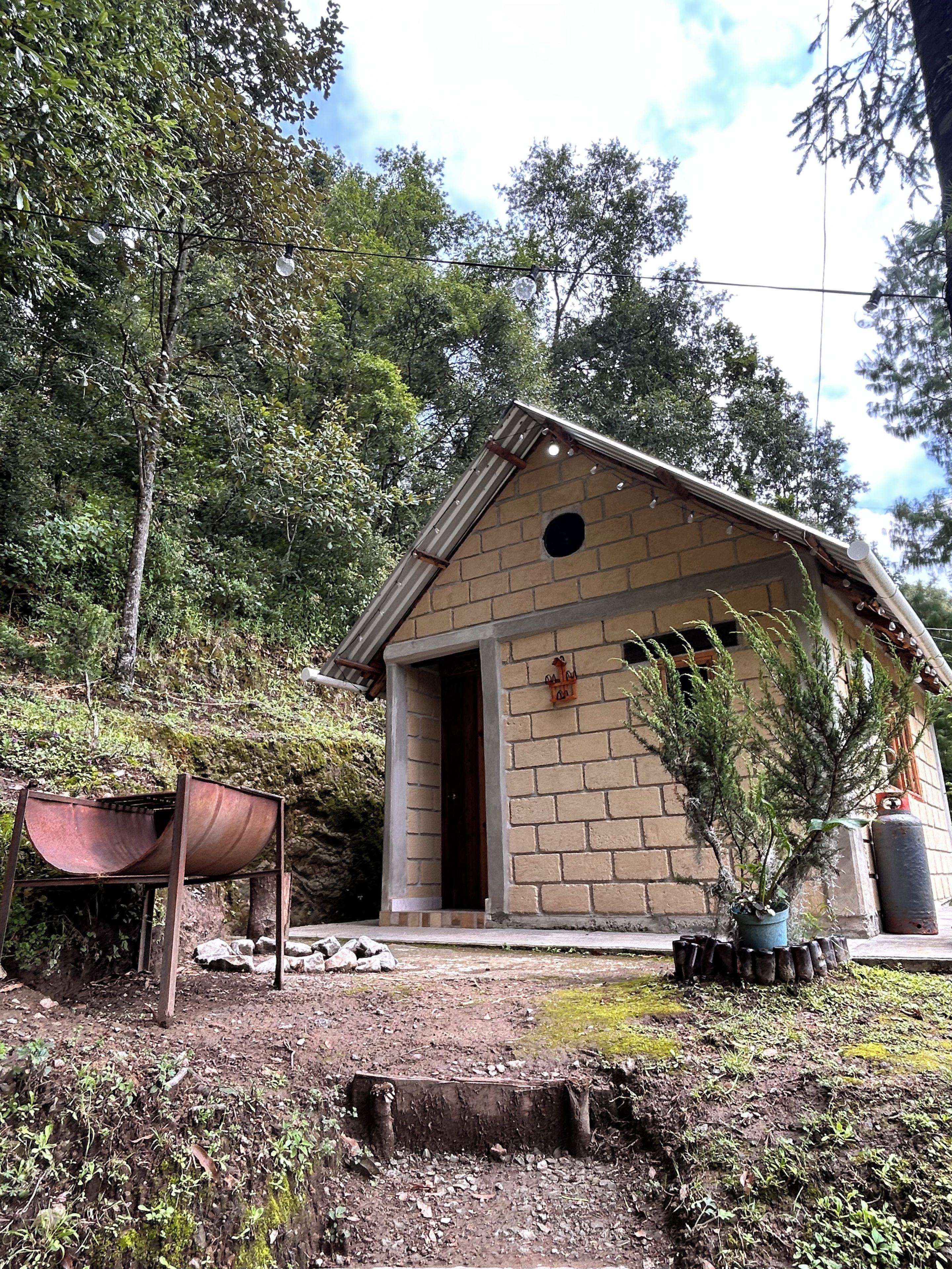 Un pequeño edificio de ladrillo con techo inclinado, una puerta y una ventana.