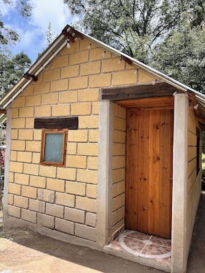 A small brick building with a wooden door and a window.