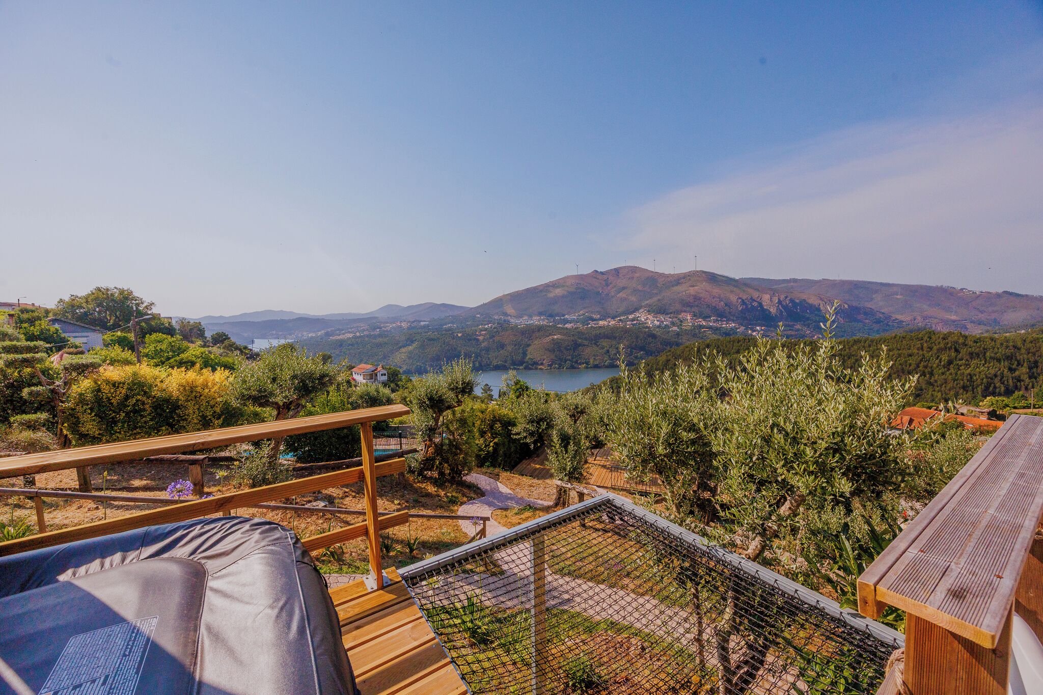 Une terrasse en bois offrant une vue sur un lac et des montagnes.