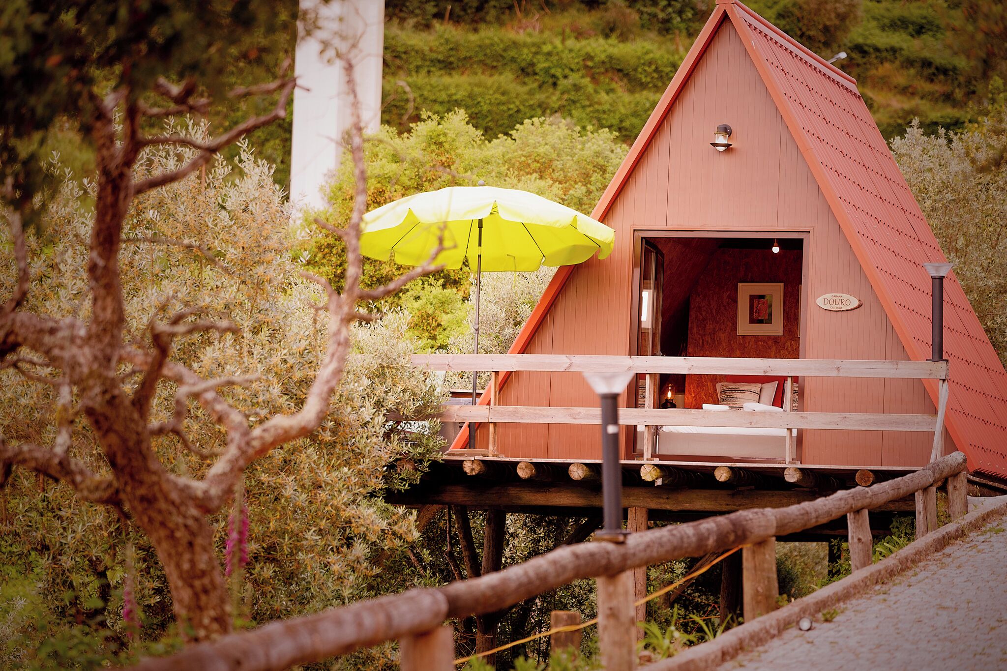 Una cabaña de madera con balcón, un paraguas amarillo y un cartel que dice 'Douro'.