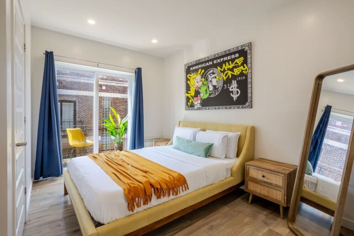 Ein modernes Hotelzimmer mit einem Bett, einem Nachttisch, einem Spiegel und einem großen Fenster mit Vorhängen.