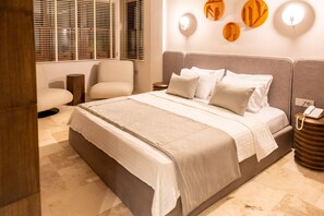 A bedroom with a bed, bedside tables, a chair, and a window with blinds. - House Sola Alaçatı (Cesme)
