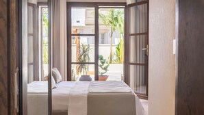 Una habitación con cama, ventana y vista al exterior.