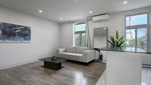 A modern living room with a sofa, a coffee table, and a large window.