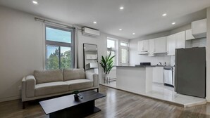 Eine moderne Wohnung mit Wohnzimmer, Küchenzeile und Essbereich.