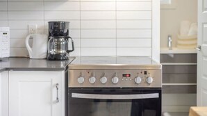A kitchen with a stove, coffee maker, and oven. - Beautiful Stay in MTL (Montreal)