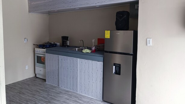 A compact kitchen with a built-in oven, a coffee maker, a refrigerator, and a sink. - Goly's Cabin - Sky with a View of Barú Volcano (Volcán)