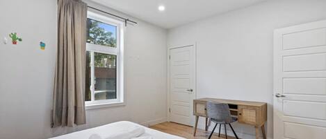 Escritorio, tabla de planchar con plancha, wifi y ropa de cama