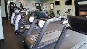 A gym with multiple treadmills, weight machines, and dumbbells. - Prairie Meadows Hotel (Altoona)