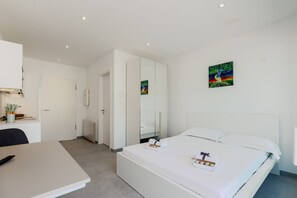 Quarto de hotel moderno com cama, escrivaninha e espelho.