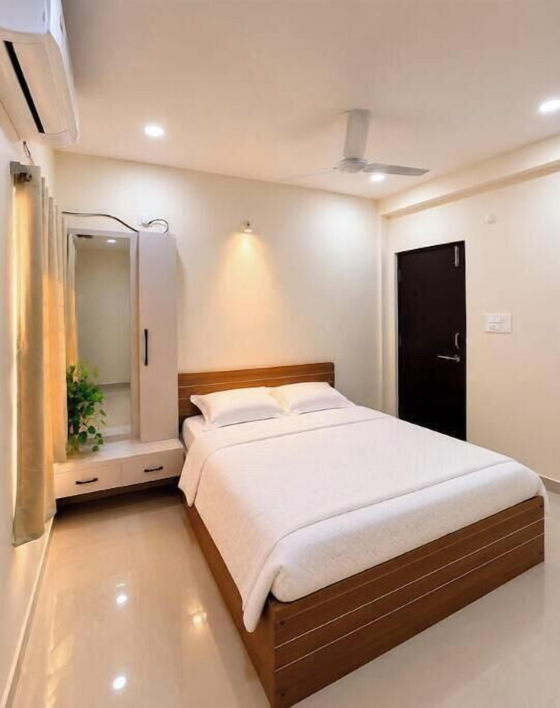 Une chambre à coucher avec un lit, une armoire, une porte et un ventilateur de plafond.