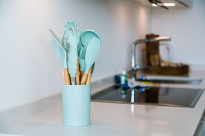A kitchen with a light blue utensil holder containing wooden-handled utensils. - {Suite 611} Gym, Business Room, Modern, Relax (Lugano)
