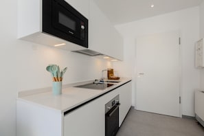 A modern kitchen with a Bosch microwave, a sink, and a dishwasher. - {Suite 611} Gym, Business Room, Modern, Relax (Lugano)