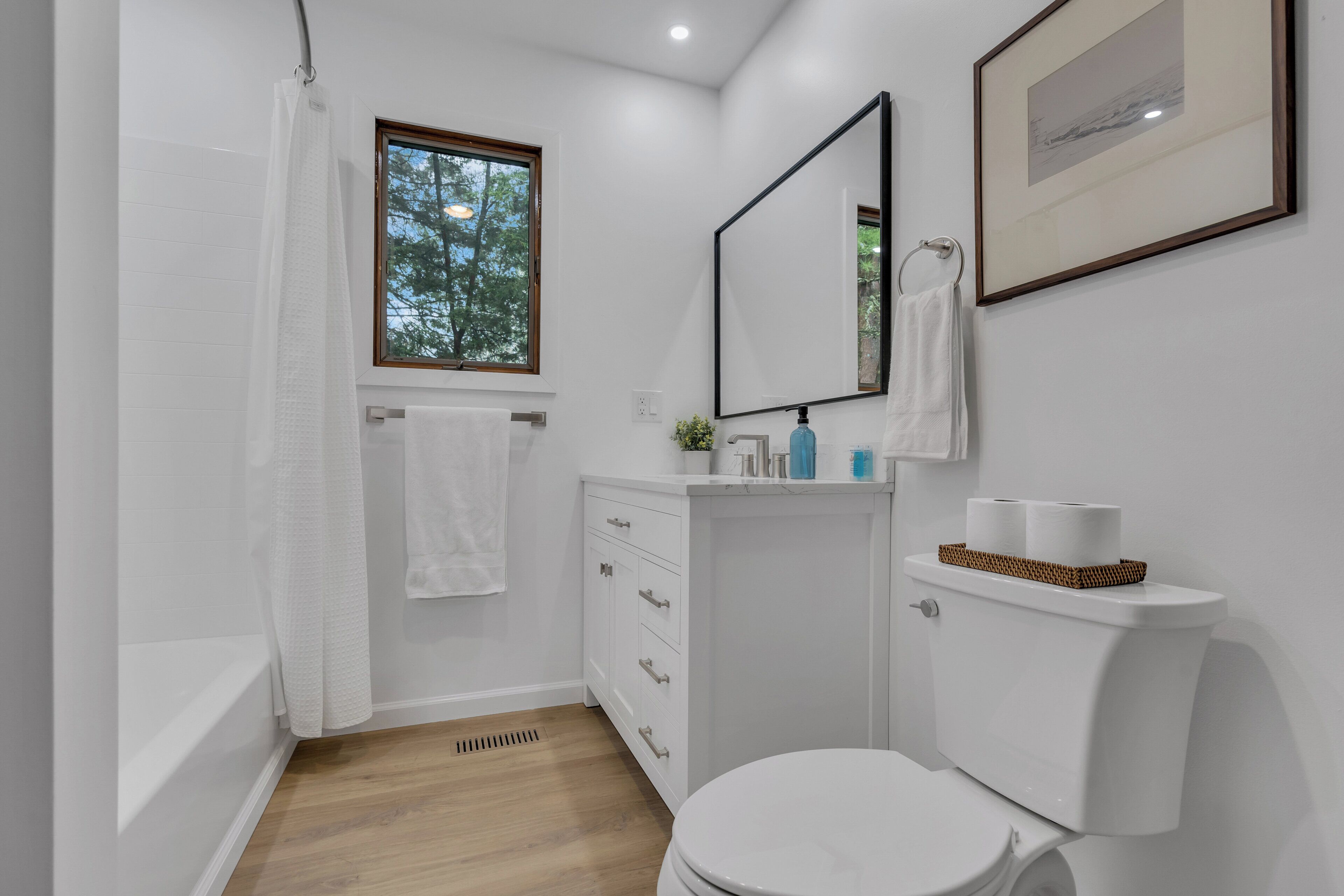 Een badkamer met toilet, wastafel en douchehoek.