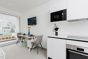 Eine moderne Küche mit Mikrowelle, Backofen und Essbereich mit Stühlen und einem Tisch.