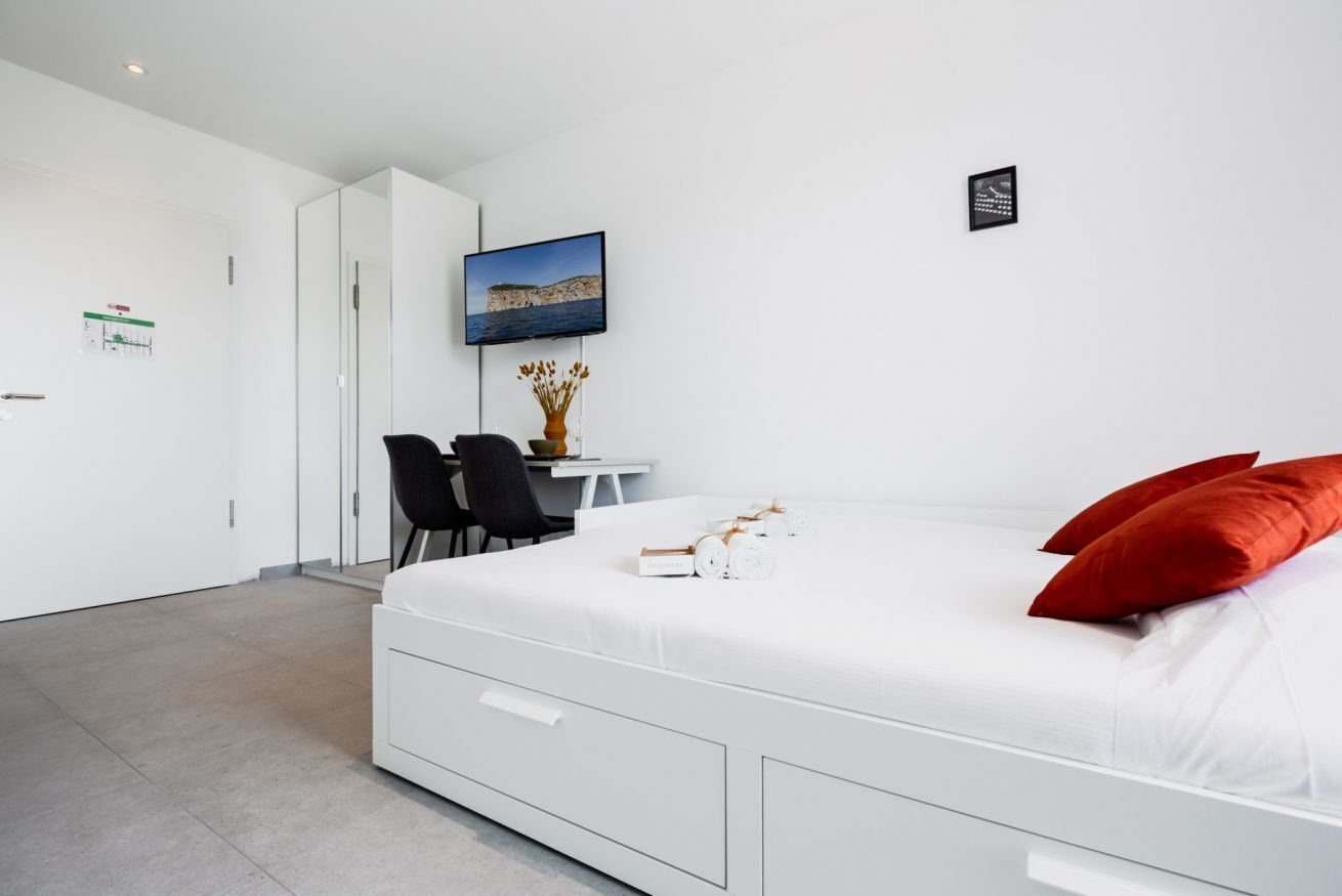 Een moderne hotelkamer met een groot bed, een bureau en een stoel.