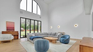 A spacious living room with a sectional sofa, a round coffee table, and a blue armchair. - Luxury 4-bedroom home with 2 kitchens, hot tub, and gym: Group & Family Retreats (Marietta)