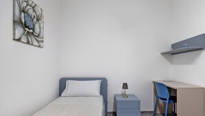 A bedroom with a bed, a desk, a chair, and a nightstand. - Apartment 'La Rocca D'amuri - Alma' with Balcony, Wi-Fi and Air Conditioning (Partinico)