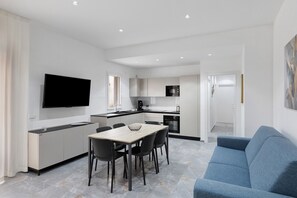 Un apartament modern amb menjador, cuina i zona d'estar.