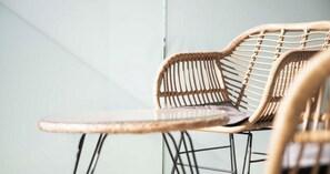 Wicker furniture with a metal frame, including a chair and a small table.