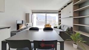 Un intérieur moderne comprenant une table à manger, des chaises, un canapé et des étagères intégrées.
