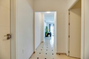 A hallway with a tiled floor, white walls, and a door on the right. - LXR La Perla, Renovated, 2-Bedroom Apt (Benalmádena)