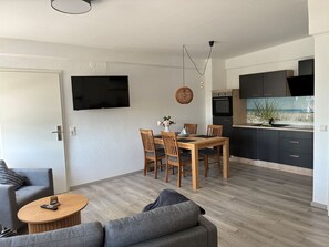 Ein moderner Wohnraum mit Essbereich, Küche und Sitzgelegenheit.