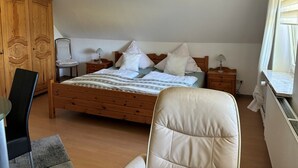 A bedroom with a wooden bed, a chair, a desk, and a wardrobe. - Hans' Vacation Rental Near the Baltic Sea with a Natural Garden (Waabs)