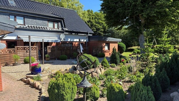 A house with a brick exterior, a sloped roof, and a satellite dish. - Hans' Vacation Rental Near the Baltic Sea with a Natural Garden (Waabs)