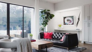 A modern living room with a sofa, a coffee table, and a large plant. - South Congress - Walk to SXSW, Downtown, ACL (Austin)