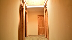 Un pasillo estrecho con puertas de madera y un tragaluz.