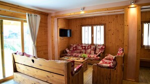 Un interior de madera con un sofá, un televisor y una ventana.