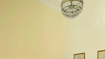A hotel room with a bed, a dresser, a fireplace, and framed pictures on the wall.
