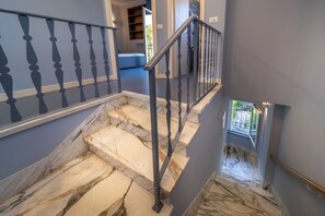 A marble staircase with a metal railing, leading to a room with a blue wall and a window. - Villa with ocean views, large garden, close to the harbor, downtown, and the beach (Rapallo)